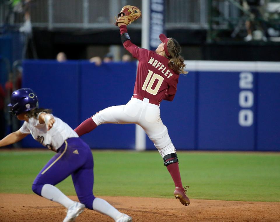 Florida State's Josie Muffley (10) makes a line drive catch behind Washington's Megan Vandegrift (2) in the seventh inning during a softball game between Washington and Florida State in the Women's College World Series at USA Softball Hall of Fame Stadium in  in Oklahoma City, Saturday, June, 3, 2023. 