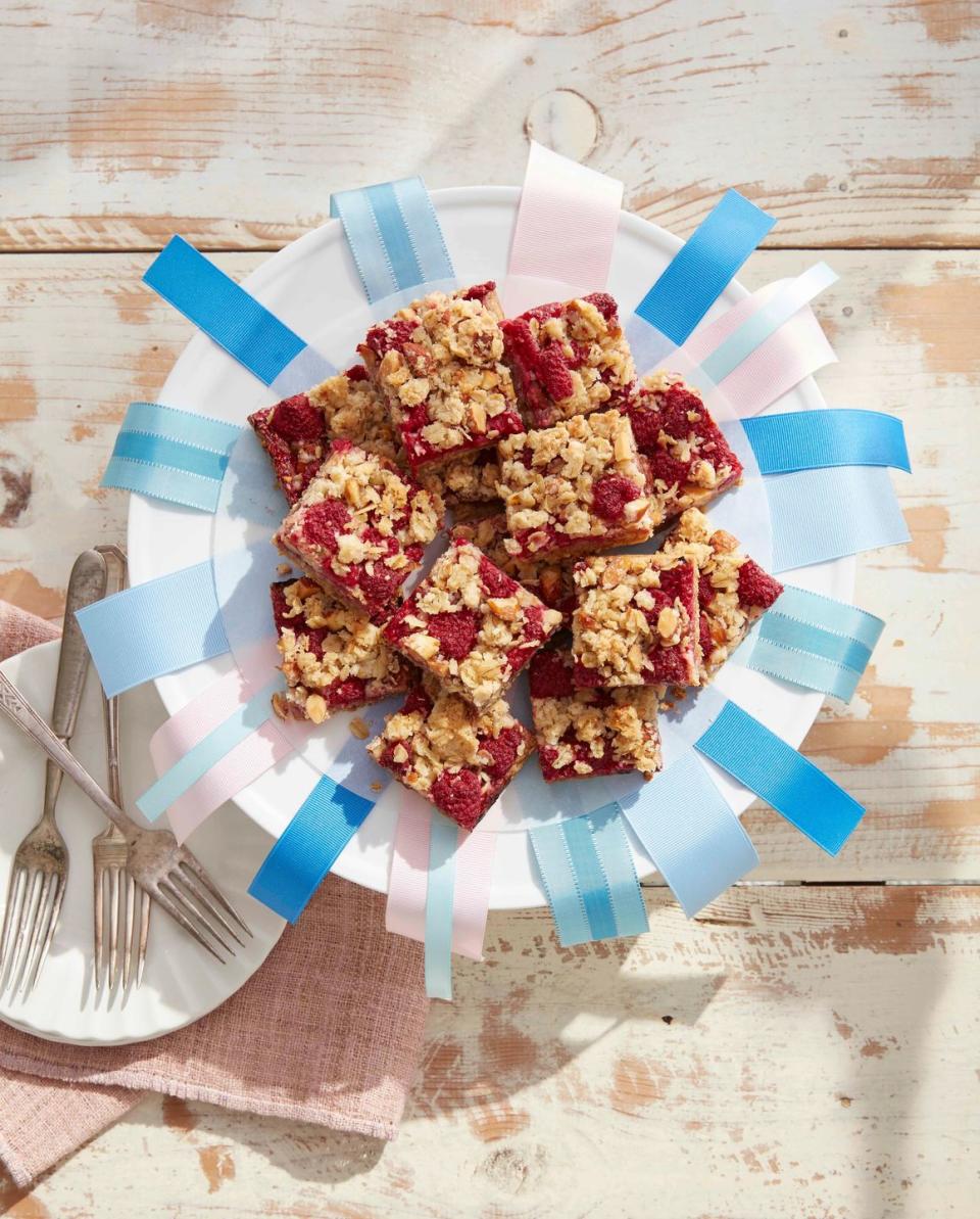 raspberry crumb bars on a plate decorated with ribbons