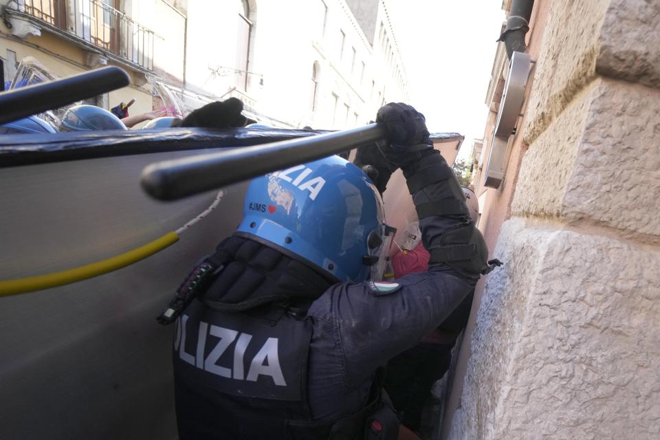 Italian Policemen in riot gears clash with demonstrators during a protest against the G20 Economy and Finance ministers and Central bank governors' meeting in Venice, Italy, Saturday, July 10, 2021. (AP Photo/Luca Bruno)