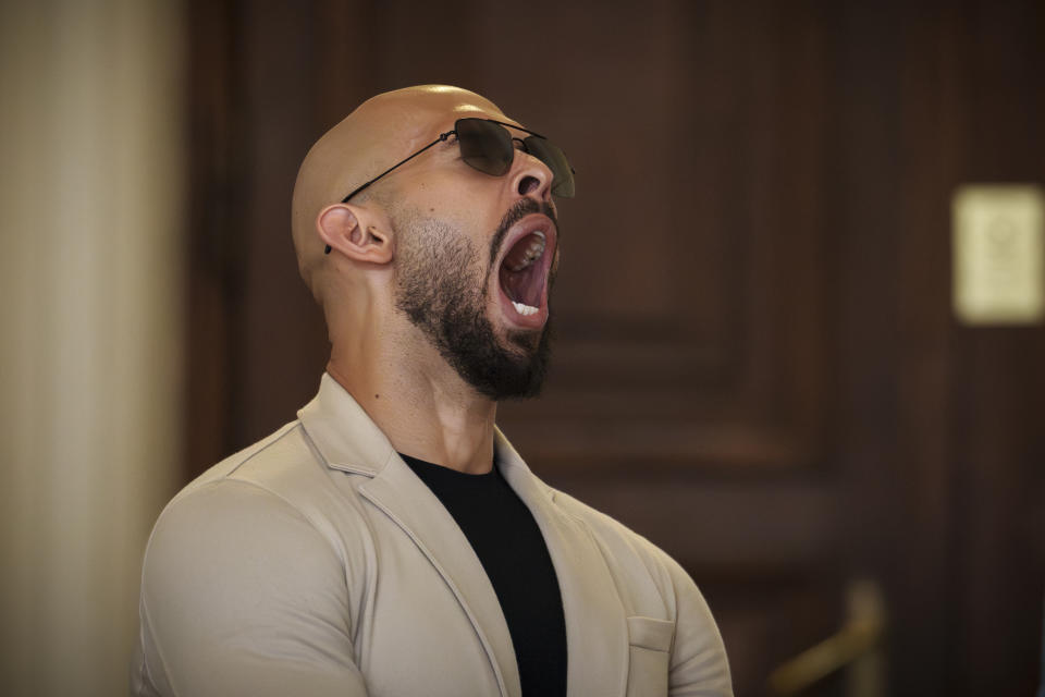 FILE - Andrew Tate yawns while waiting for his hearing inside the Court of Appeals building in Bucharest, Romania, Wednesday, June 26, 2024. A court in Romania's capital on Friday, July 5, 2024 ruled that the online influencer Andrew Tate can leave Romanian territory providing he remains within the European Union, as he awaits trial on charges of human trafficking, rape and forming a criminal gang to sexually exploit women. (AP Photo/Vadim Ghirda, File)