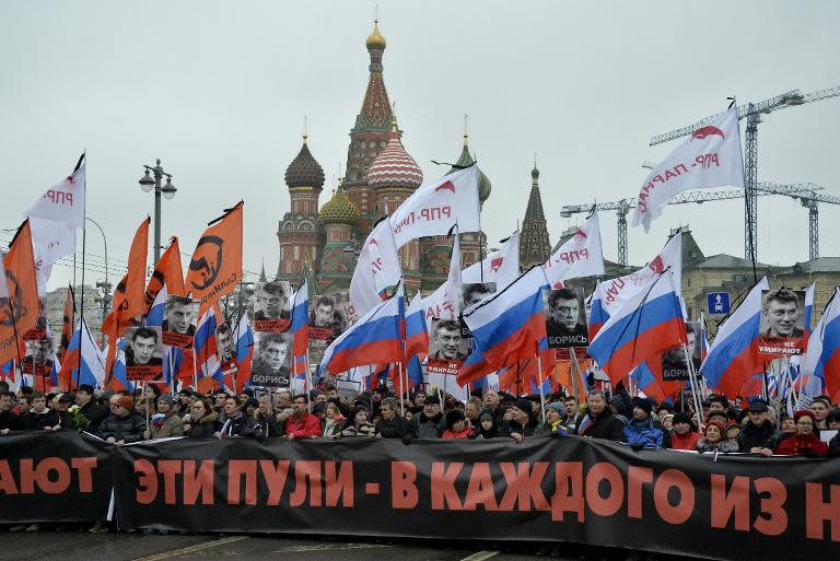 Russia's opposition supporters carry a banner reading “These bullets in each of us” during a march in memory of murdered Kremlin critic Boris Nemtsov in central Moscow on March 1, 2015