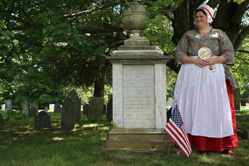 Jackie Coughlin, an interpreter with the Boston Tea Party Ships & Museum, stands beside the grave of Nicholas Cambell in Warren's North Burial Ground on Monday before placing a medallion marking his participation in the Boston Tea Party in 1773.