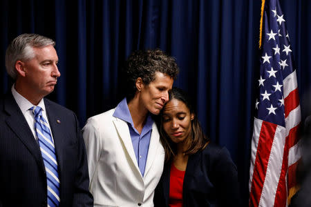 Bill Cosby accuser Andrea Constand embraces Special Prosecutor Kristen Gibbons Feden as Montgomery County District Attorney Kevin Steele looks on during a news conference after a jury convicted actor and comedian Bill Cosby for sexual assault during a retrial in Norristown, Pennsylvania, U.S., April 26, 2018. REUTERS/Brendan McDermid