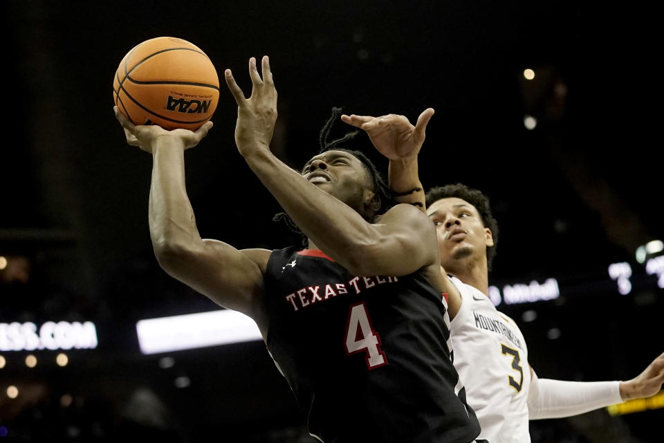 Texas Tech forward Robert Jennings (4) shoots under pressure from West Virginia forward Tre Mitchell (3) during the first half of an NCAA college basketball game in the first round of the Big 12 Conference tournament Wednesday, March 8, 2023, in Kansas City, Mo. (AP Photo/Charlie Riedel)