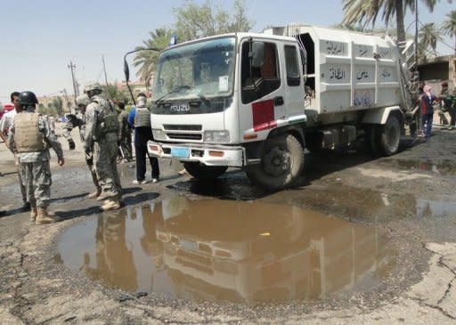 Iraqi security forces inspect the scene of two car bombs that ripped through a group of policemen outside the local ogvernor's home in the central Iraqi city of Diwaniyah. Two suicide car bombs ripped through a guard post killing 26 people outside the provincial governor's home in Diwaniyah city, officials said, as violence surged across Iraq