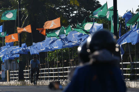 A cyclist passes election flags in Kota Bharu, Kelantan, Malaysia April 12, 2018. Picture taken April 12, 2018. REUTERS/Stringer