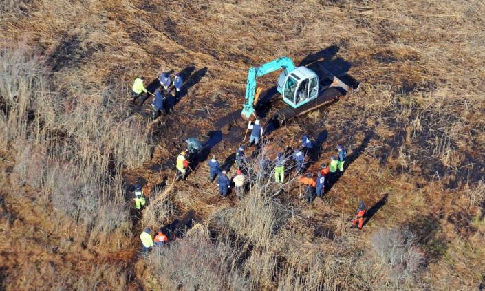 aerial view of digger and and people searching