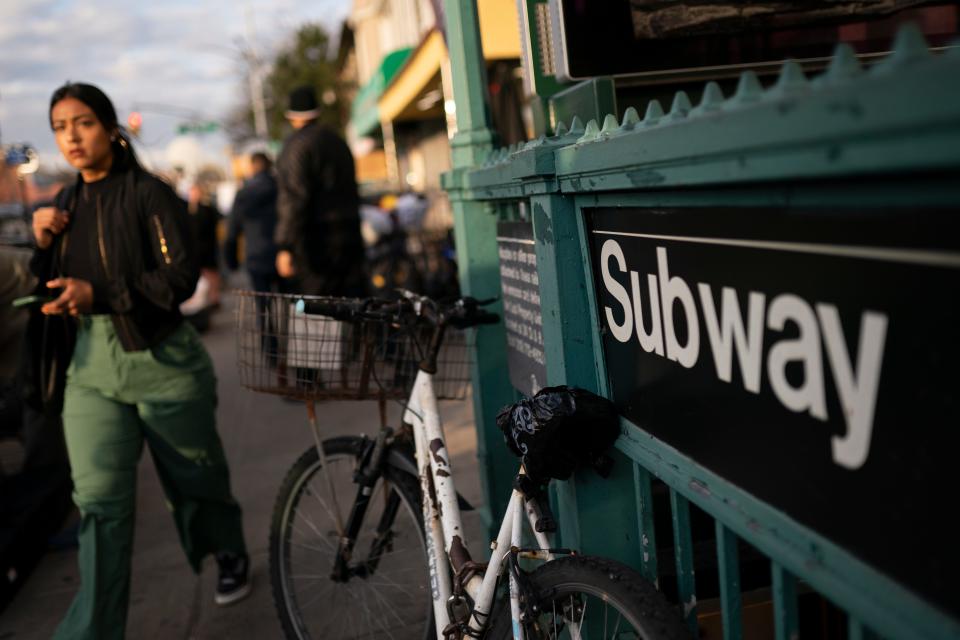 Pedestrians pass the 36th Street subway station where a shooting attack occurred the previous day during the morning commute, Wednesday, April 13, 2022, in New York.