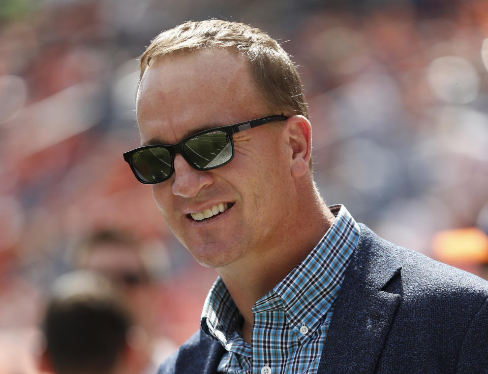 FILE - In this Sept. 16, 2018, file photo, former Denver Broncos quarterback Peyton Manning watches prior to an NFL football game against the Oakland Raiders, in Denver. Just as he had the true touch when he threw passes, set records and won two Super Bowls on the field, Peyton Manning possesses the right approach to look back at some of the NFL’s greatest moments. Manning, a lock for the Pro Football Hall of Fame when he becomes eligible in 2021, is hosting and serves as one of the executive producers for “Peyton’s Places,” a five-part, 30-episode series that celebrates the NFL’s 100th season.(AP Photo/Jack Dempsey, File)