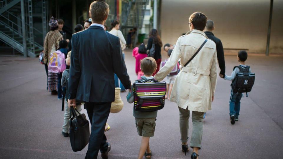 Des parents et leur enfant dans une cour d'école (photo d'illustration) - Martin Bureau-AFP