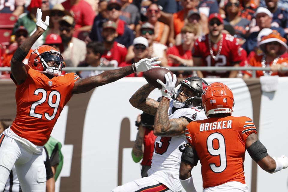 Tampa Bay Buccaneers wide receiver Mike Evans (13) catches a touchdown pass under pressure from Chicago Bears cornerback Tyrique Stevenson (29) and Chicago Bears safety Jaquan Brisker (9) during the second half of an NFL football game, Sunday, Sept. 17, 2023, in Tampa, Fla. (AP Photo/Scott Audette)