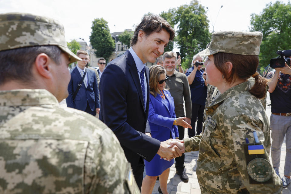 Canadian Prime Minister Justin Trudeau speaks with Ukrainian soldiers as he visits the Wall of Remembrance, in Kyiv, Ukraine, Saturday June 10, 2023. (Valentyn Ogirenko/Pool via AP)