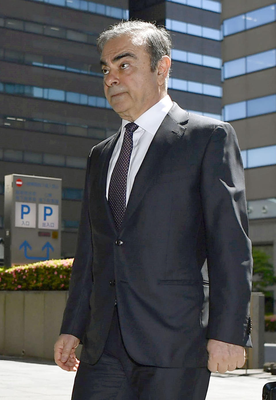 Former Nissan chairman Carlos Ghosn arrives at Tokyo District Court for a pre-trial meeting in Tokyo Thursday, May 23, 2019. Ghosn, who is out on bail, has been charged with under-reporting his post-retirement compensation and breach of trust in diverting Nissan money and allegedly having it shoulder his personal investment losses., lawyer of (Ren Onuma/Kyodo News via AP)