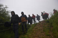 Pilgrims of St. James Way walk at the area of El Perdon mountain, near to Pamplona northern northern Spain, Tuesday, June 1, 2021. The pilgrims are trickling back to Spain's St. James Way after a year of being kept off the trail due to the pandemic. Many have committed to putting their lives on hold for days or weeks to walk to the medieval cathedral in Santiago de Compostela in hopes of healing wounds caused by the coronavirus. (AP Photo/Alvaro Barrientos)