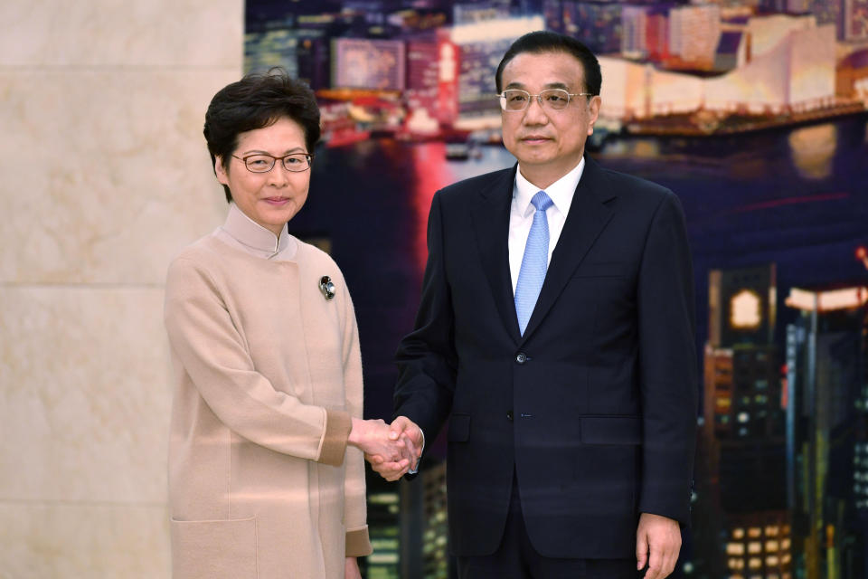 En esta imagen proporcionada por los Servicios de Información del Gobierno de Hong Kong, la directora general del territorio, Carrie Lam, a la izquierda, con el premier chino, Li Keqiang, posando para una foto durante su reunión en Beijing, el lunes 16 de diciembre de 2019. (Hong Kong Government Information Services via AP)