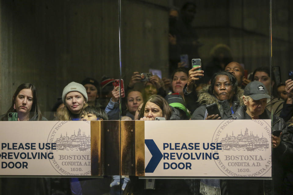 People wait for Britain's Prince William and Kate, Princess of Wales, to walk through the lobby of Boston City Hall on Wednesday, Nov. 30, 2022, in Boston, Mass. (AP Photo/Reba Saldanha)