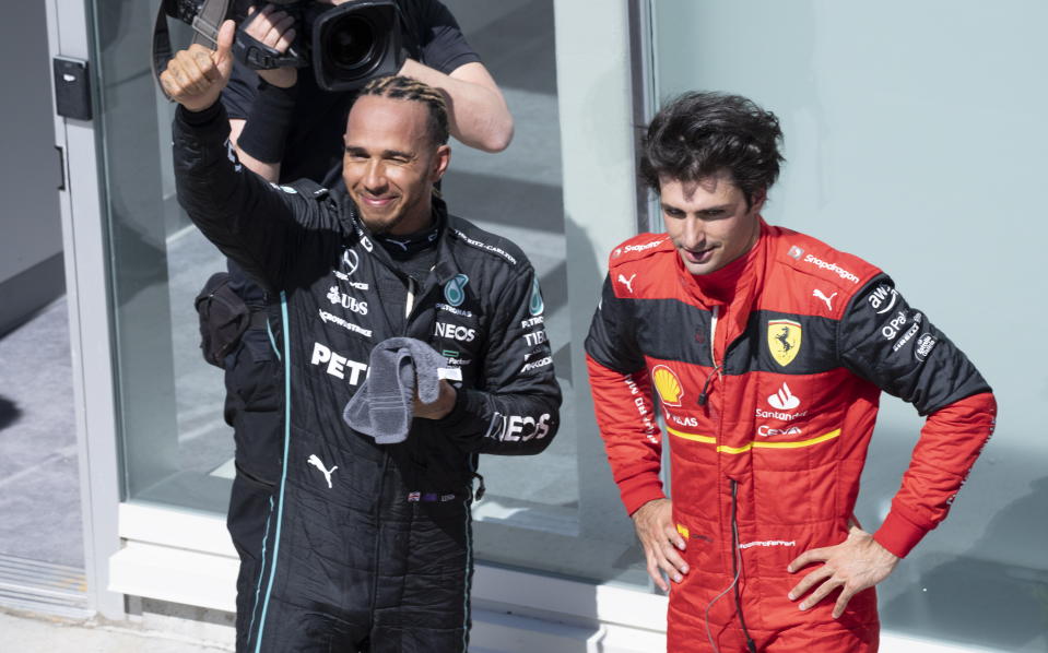 Third-place Mercedes Team Lewis Hamilton, left, of Britain, greets the crowd next to second-place finisher Scuderia Ferrari driver Carlos Sainz, of Spain, at the Canadian Grand Prix auto race Sunday, June 19, 2022, in Montreal. (Paul Chiasson/The Canadian Press via AP)