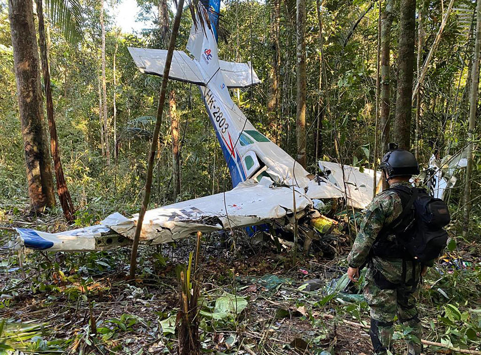 Cette photo publiée le 19 mai 2023 par l’armée colombienne montre un soldat debout à côté de l’épave du petit avion qui s’est écrasé dans la forêt amazonienne, dans la municipalité de Solano, au début du mois.