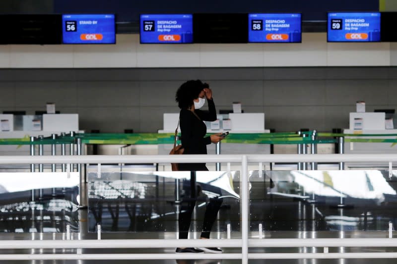 A traveller wearing a protective face mask walks at Brazilian International Airport amid the coronavirus disease (COVID-19) outbreak in Brasilia