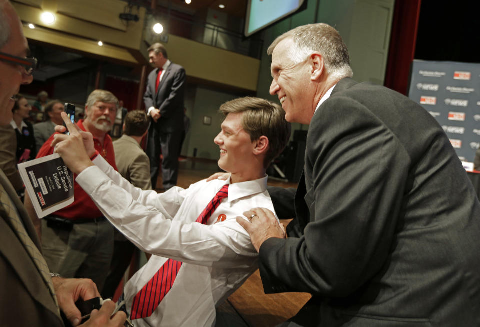 Republican senatorial candidate Thom Tillis, right, has a "selfie" taken with a supporter before a debate at Davidson College in Davidson, N.C., Tuesday, April 22, 2014. (AP Photo/Chuck Burton)