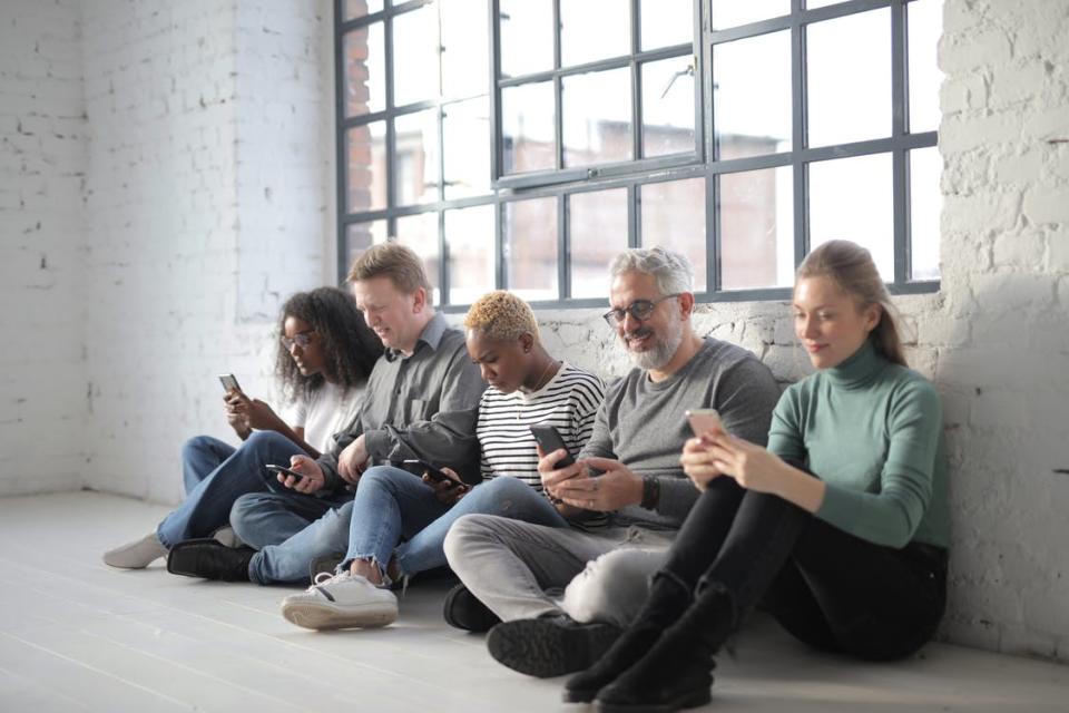 Diverse people surfing internet on smartphone in afternoon