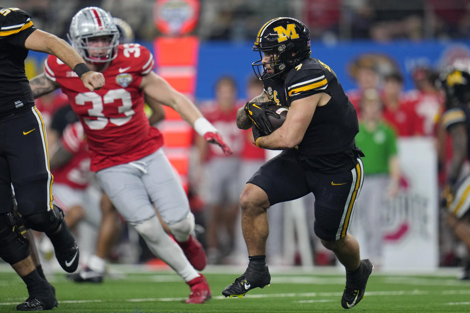 Missouri running back Cody Schrader, right, runs against Ohio State defensive end Jack Sawyer (33) during the first half of the Cotton Bowl NCAA college football game Friday, Dec. 29, 2023, in Arlington, Texas. (AP Photo/Julio Cortez)