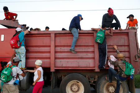 Eight months pregnant Honduran migrant Erly Marcial, 21, and her husband Alvin Reyes, 39, board a truck as they hitch a ride towards the U.S., in Santo Domingo Ingenio, Mexico, November 8, 2018. REUTERS/Carlos Garcia Rawlins