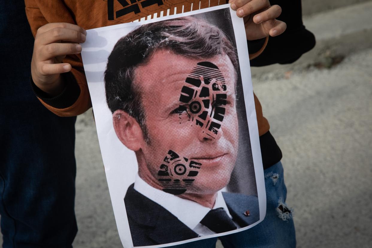 A protester holds up an image of Emmanuel Macron during demonstrations in Istanbul on Sunday (Getty Images)