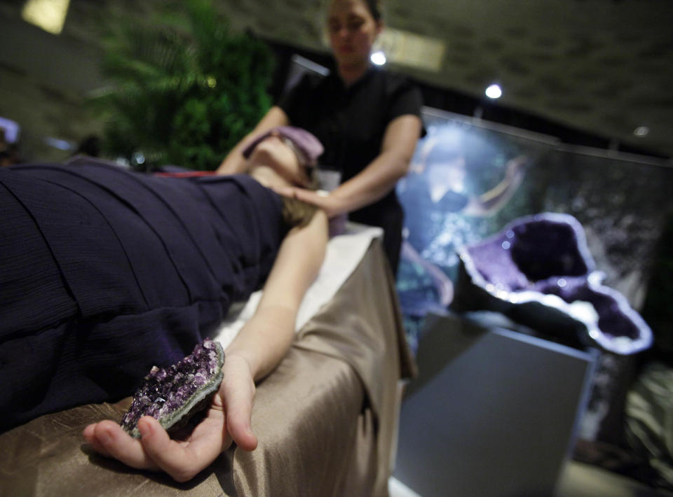 Thia Aug. 16, 2012 photo shows a woman receiving the Indigo Journey treatment at a booth by Aspira Spa, at the Osthoff Resort in Elkhart Lake, Wiisc., at the International Spa Association event, in New York. Parties at the spa, treatments for stressed and time-pressed consumers, cross-cultural traditions, and a whole lot of purple _ from lavender-scented treatments to mauve nail polish _ are some of the trends and services that were shown off at the annual International Spa Association meeting held recently in New York. (AP Photo/Richard Drew)