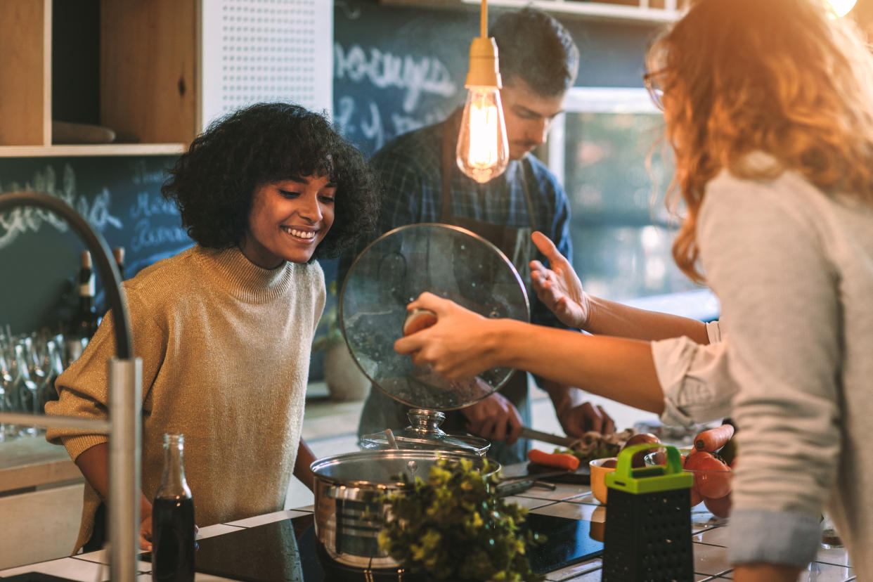 Friends cooking together. (Getty Images)