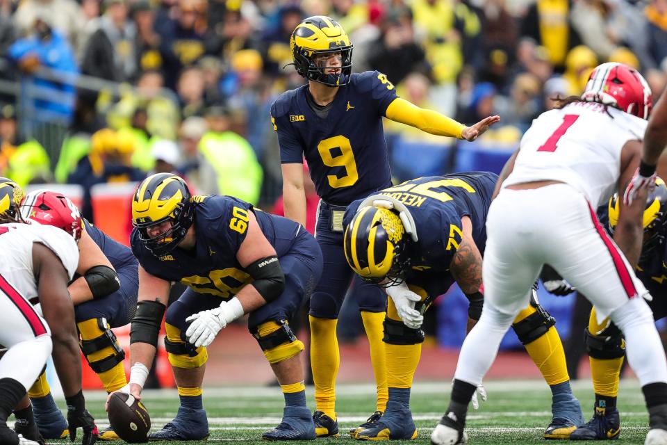 Michigan quarterback J.J. McCarthy talks to teammates before taking a snap from center Drake Nugent against Indiana during the first half at Michigan Stadium in Ann Arbor on Saturday, Oct. 14, 2023.