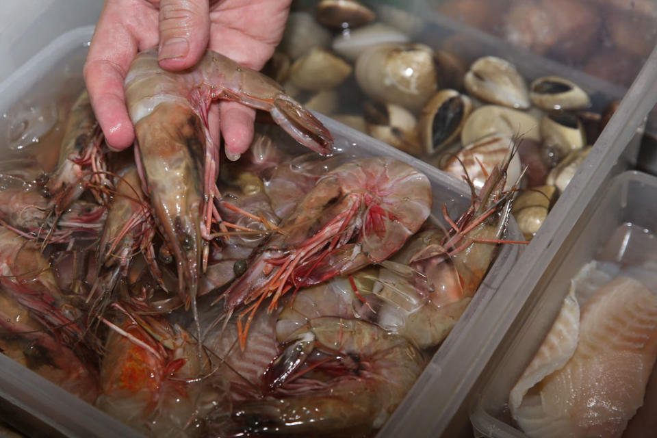 Seafood like prawns, clams and fish are prepped for cooking.