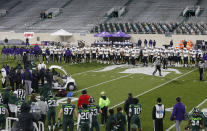 Northwestern players watch at midfield as receiver Berkeley Holman receives medical attention and is carted off the field during the fourth quarter of the team's NCAA college football game against Michigan State, Saturday, Nov. 28, 2020, in East Lansing, Mich. Michigan State won 29-20. (AP Photo/Al Goldis)