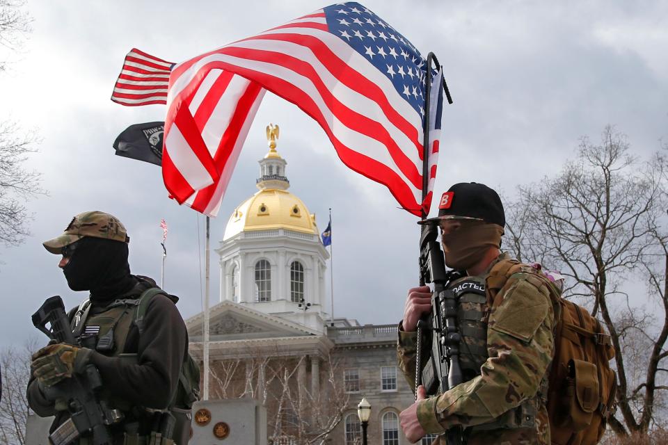 Armed protesters stand in front of the Statehouse on Sunday, Jan. 17, 2021, in Concord, N.H.