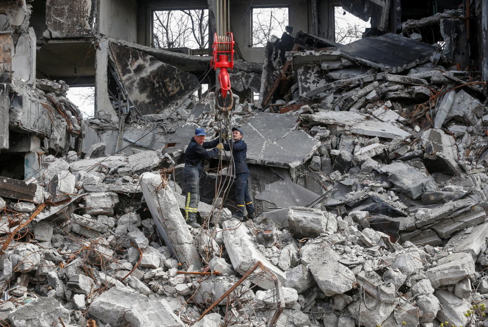 Emergency workers remove debris of a building destroyed in the course of the Ukraine-Russia conflict, in the southern port city of Mariupol, Ukraine April 10, 2022. REUTERS/Alexander Ermochenko