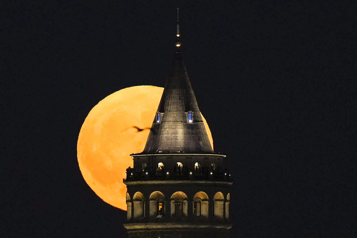 A supermoon rises behind the Galata Tower in Istanbul on Monday.