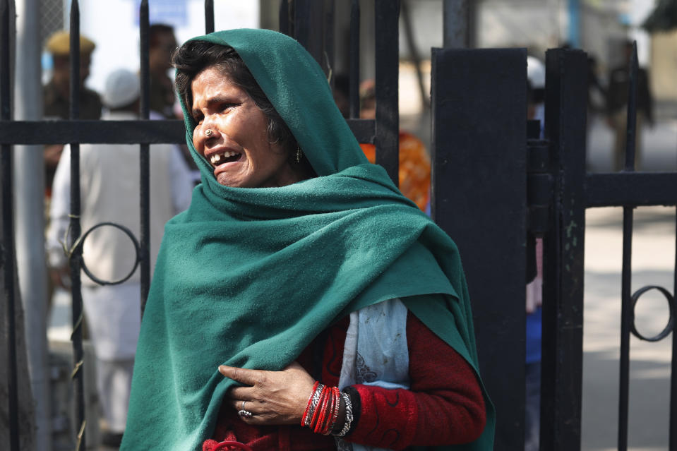 A woman cries outside a mortuary as she waits to receive the body of a relative who died in Sunday's fire in New Delhi, India, Monday, Dec. 9, 2019. Authorities say an electrical short circuit appears to have caused a devastating fire that killed dozens of people in a crowded market area in central New Delhi. Firefighters fought the blaze from 100 yards away because it broke out in one of the area's many alleyways, tangled in electrical wire and too narrow for vehicles to access. (AP Photo/Manish Swarup)