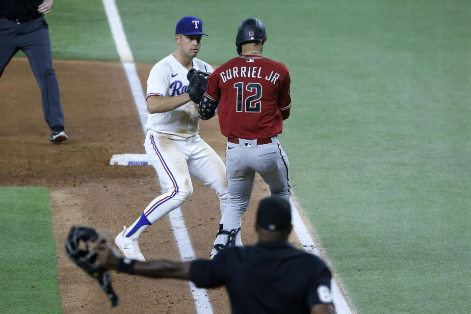 Texas Rangers first baseman Nathaniel Lowe , left, tags out Arizona Diamondbacks left fielder Lourdes Gurriel Jr. (12) during the fifth inning of a baseball game against the Texas Rangers, Tuesday, May 2, 2023, in Arlington, Texas. (AP Photo/Michael Ainsworth)