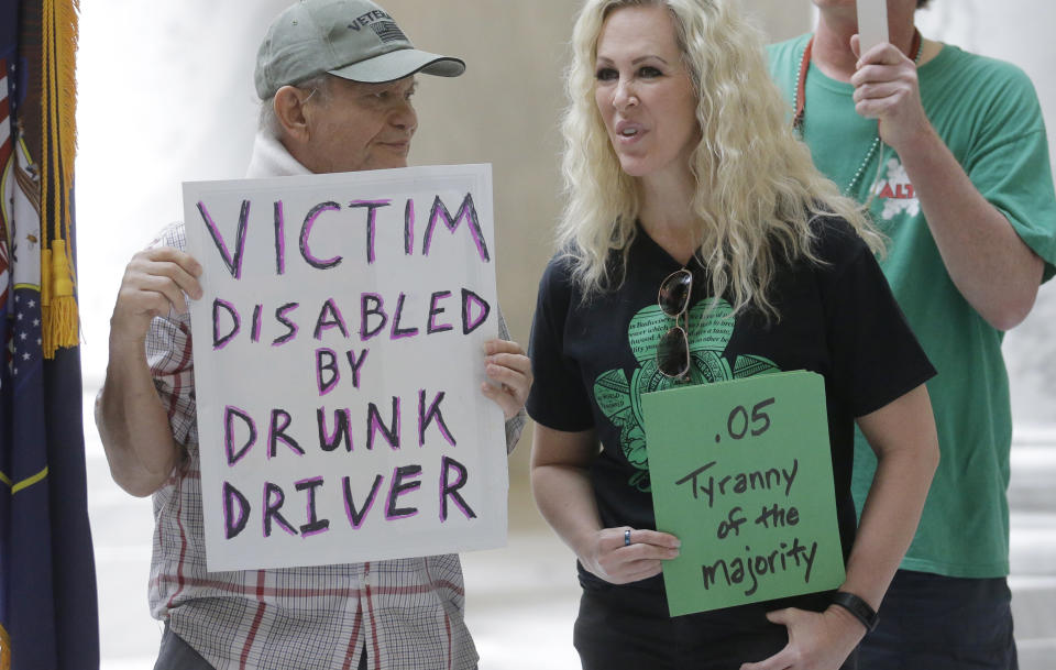 FILE - In this March 17, 2017, file photo, Ed Staley, left, and Tali Bruce, right, attend a rally concerning the DUI threshold at the Utah state Capitol in Salt Lake City. The United States' lowest DUI threshold takes effect this weekend in Utah. Lawmakers in the state approved the 0.05 percent blood-alcohol limit in 2017, and Gov. Gary Herbert signed it into law. The change goes into effect Saturday, Dec. 29, 2018. (AP Photo/Rick Bowmer, File)