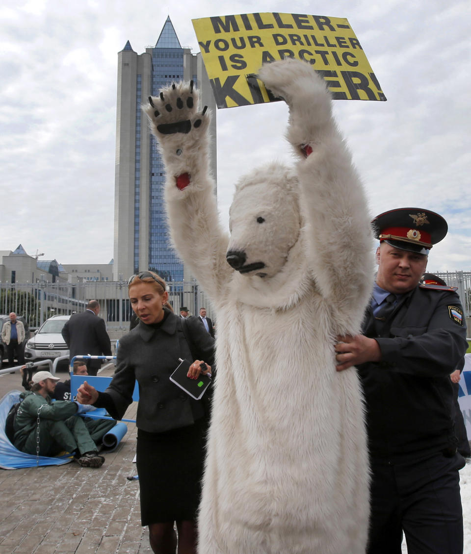 A police officer detains s Greenpeace activist dressed as a polar bear outside Gazprom's headquarters in Moscow, Russia, Wednesday, Sept. 5, 2012. Russian and international environmentalists are protesting against Gazprom's plans to pioneer oil drilling in the Arctic. (AP Photo/Misha Japaridze)