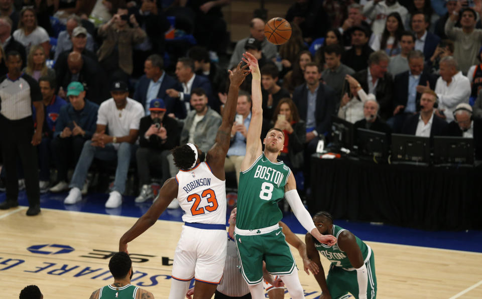 New York Knicks center Mitchell Robinson (23) and Boston Celtics center Kristaps Porzingis (8) jump for the opening tip during the first half of an NBA basketball game Wednesday, Oct. 25, 2023, in New York. (AP Photo/John Munson)