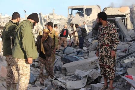 Fighters of Libyan forces allied with the U.N.-backed government gather atop the ruins of a house as they are close to securing last Islamic State holdouts in Sirte, Libya December 5, 2016. REUTERS/Ayman Sahely