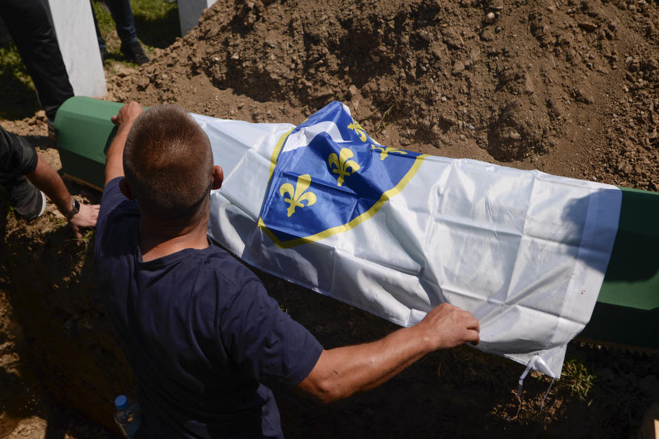 A massacre victim's remains are burried in Potocari, near Srebrenica, Bosnia, Saturday, July 11, 2020. Mourners converged on the eastern Bosnian town of Srebrenica for the 25th anniversary of the country's worst carnage during the 1992-95 war and the only crime in Europe since World War II that has been declared a genocide. (AP Photo/Kemal Softic)