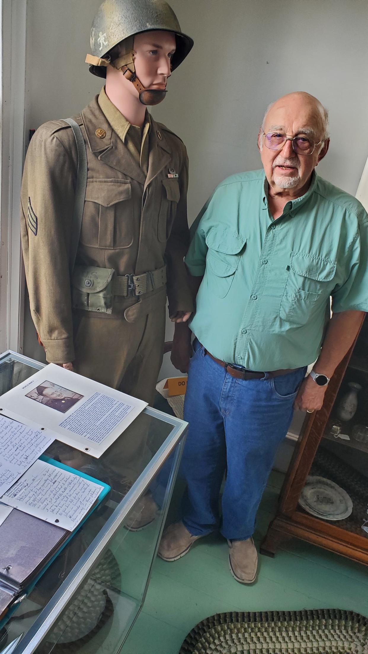 Rick Devine, a trustee of the Historical Society of Olde Northfield, stands next to a mannequin dressed with the uniform of Charles J. Schoepf, a Northfield veteran of World War II.