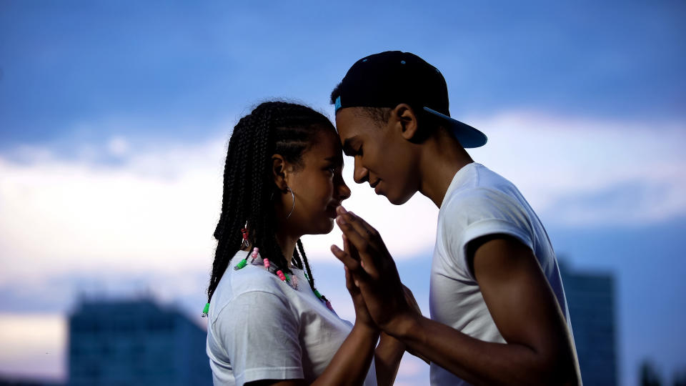 a teen guy and girl hugging