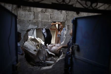 Palestinians inspect their house that witnesses said was destroyed during an Israeli airstrike in the northern of Gaza Strip August 21, 2014. REUTERS/Mohammed Salem