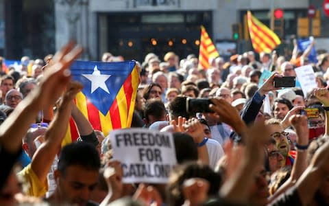 A crowd of protesters gather outside the Catalan region's economy ministry after junior economy minister Josep Maria Jove was arrested  - Credit: REUTERS