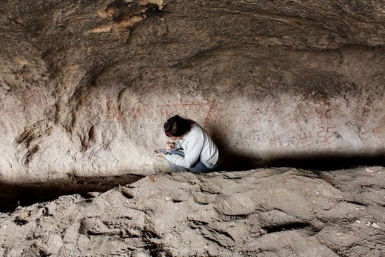 La arqueóloga Guadalupe Romero Villanueva registra las pinturas en la cueva Huenul 1, en el noroeste de la Patagonia