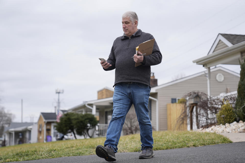Jim Prokopiak, Democratic nominee for a Bucks County special election to fill a vacant Pennsylvania state House seat, looks up the next address as he knocks on voters doors in Levittown, Pa., Tuesday, Jan. 30, 2024. (AP Photo/Matt Rourke)