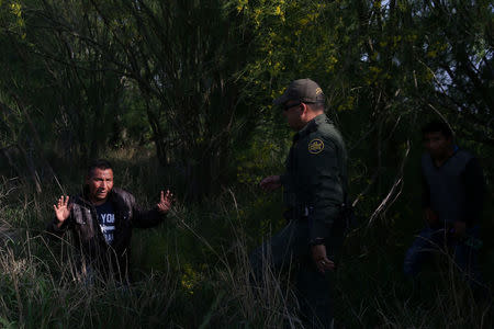 Border patrol agent Sergio Ramirez apprehends immigrants who illegally crossed the border from Mexico into the U.S. in the Rio Grande Valley sector, near McAllen, Texas, U.S., April 2, 2018. REUTERS/Loren Elliott